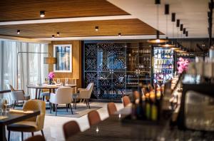 a restaurant with tables and chairs and a wine cellar at Hotel Ambasador - Liburnia in Opatija