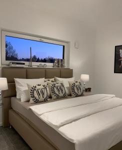 ein weißes Schlafzimmer mit einem großen Bett mit Kissen in der Unterkunft Ambiente Apartments in Naumburg