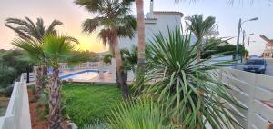 a view from the balcony of a house with palm trees at * Casa del Diamante - Meer- und Buchtblick VILLA * in Cala Pi