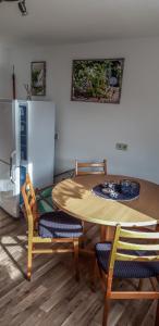 eine Küche mit einem Tisch und Stühlen sowie einem Kühlschrank in der Unterkunft Pension Muldental Großbothen in Grimma