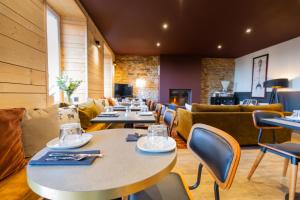 a restaurant with tables and chairs and couches at Ty Mad Hôtel in Groix