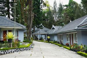una fila de casas con plantas y árboles en Rudang Hotel & Resort Berastagi, en Berastagi