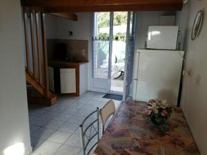 een keuken met een tafel en een koelkast bij abri/cotier in Châtelaillon-Plage +17 foto's