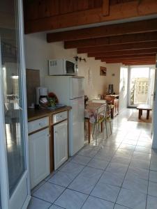 een keuken met witte apparatuur en een eetkamer met een tafel bij abri/cotier in Châtelaillon-Plage