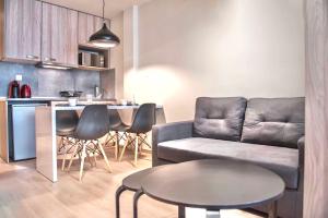 ein Wohnzimmer mit einem Sofa und einem Tisch in der Unterkunft #Aura Studios & Suites V9-10 in Thessaloniki