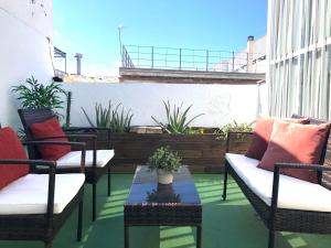 eine Terrasse mit 2 Stühlen und einem Tisch auf dem Balkon in der Unterkunft Plaza Nueva Terraza in Sevilla