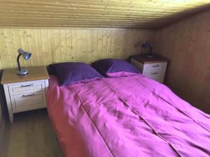 een slaapkamer met een roze bed en 2 nachtkastjes bij Chalet Le Biolley 2 in Orsières