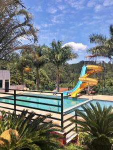 a swimming pool with a slide in a resort at Recanto Julubi Atibaia in Atibaia