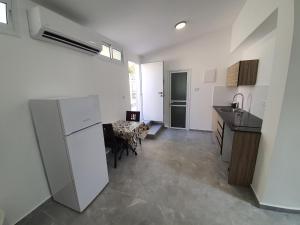 una cucina con frigorifero bianco e tavolo di Eilat vacation studio סטודיו נופש באילת a Eilat