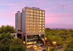 un edificio blanco alto con luces encendidas en Welcomhotel by ITC Hotels, Ashram Road, Ahmedabad, en Ahmedabad