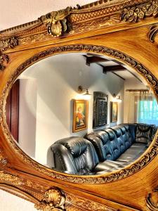 a mirror with a couch in a living room at Apfelhaus in Cisnădioara