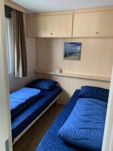 zwei Betten in einem Zimmer mit blauen Kissen in der Unterkunft RBR 655 - Beach Resort Kamperland in Kamperland