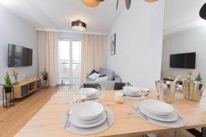 a living room with a table with plates on it at Maloves Apartment NETFLIX in Łódź