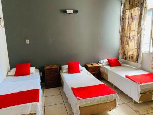 a room with two beds with red pillows at Viareggio Hotel - Niteroi in Niterói