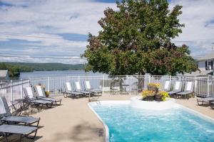 uma piscina numa varanda com cadeiras e uma árvore em Lake Bomoseen Lodge em Bomoseen