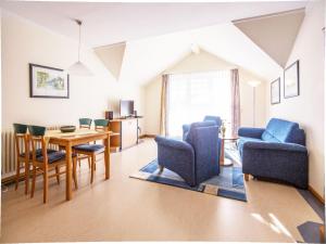 ein Wohnzimmer mit Esstisch und Stühlen in der Unterkunft Dünenpark Binz - Komfort Ferienwohnung mit 1 Schlafzimmer und Balkon im Dachgeschoss 234 in Binz