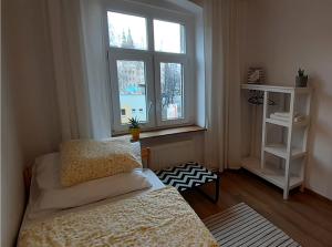 a small bedroom with two beds and a window at Lemuria Hostel Szkolna centrum in Legnica
