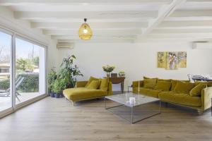 - un salon avec des canapés jaunes et une table dans l'établissement La Maison Mora - Welkeys, à Boucau