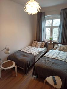 a bedroom with two beds and a chandelier at Lemuria Hostel Szkolna centrum in Legnica