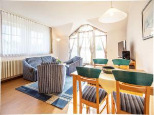 ein Wohnzimmer mit Tisch und Stühlen in der Unterkunft Dünenpark Binz - Komfort Ferienwohnung mit 1 Schlafzimmer und Balkon im Dachgeschoss 236 in Binz
