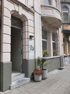 um edifício com dois vasos de plantas na frente de uma porta em 't Zandmanneke em Ostend