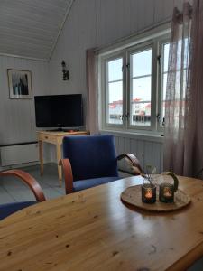 ein Wohnzimmer mit einem Holztisch und 2 Stühlen in der Unterkunft Fiskekrogen Rorbuer in Henningsvær