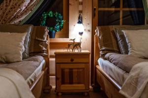 a room with two beds and a table with a toy deer on it at Domki Pod Reglami in Zakopane