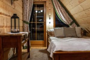 a bedroom with two beds and a table and a window at Domki Pod Reglami in Zakopane