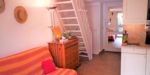 ヴィルヌーヴ・ルベにあるRésidence Cap Azur Maison N° 26のベッドルーム1室(ベッド1台、ドレッサー、階段付)