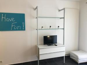 a living room with a tv and a shelf at PETIT NID AU BOURGET DU LAC in Le Bourget-du-Lac