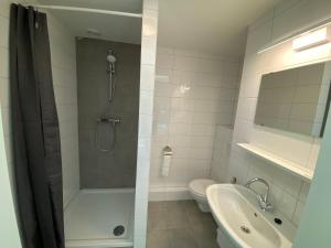 a bathroom with a shower and a toilet and a sink at Short Stay Wageningen in Wageningen