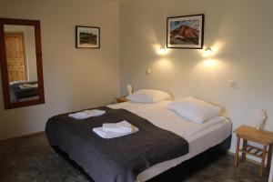 a bedroom with a bed with two towels on it at H&oacute;tel &Aacute; in Reykholt