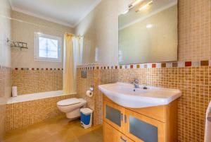 a bathroom with a sink and a toilet and a mirror at Villa Margarita in Cala d´Or +21 photos