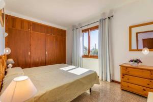 a bedroom with a bed and a dresser and a window at Villa Margarita in Cala d´Or