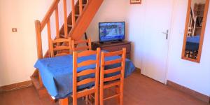 ヴィルヌーヴ・ルベにあるRésidence Cap Azur Maison N° 106のテレビとテーブルが備わる階段付きの客室です。