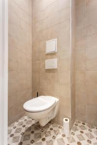 a bathroom with a toilet and a tiled floor at CMG Saint Louis- Vaucouleurs in Paris