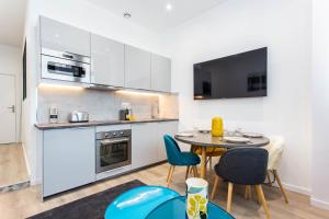 a kitchen with a table and chairs in a room at CMG Saint Louis- Vaucouleurs in Paris