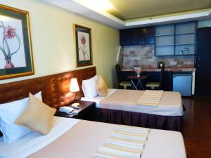 a hotel room with two beds and a kitchen at Silver Oaks Suites & Hotel in Manila