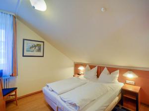 ein Schlafzimmer mit einem Bett mit weißen Laken und Kissen in der Unterkunft Dünenpark Binz - Komfort Ferienwohnung mit 1 Schlafzimmer und Balkon im Dachgeschoss 293 in Binz