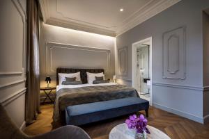 a bedroom with a large bed and a table at Hotel Ambasador - Liburnia in Opatija