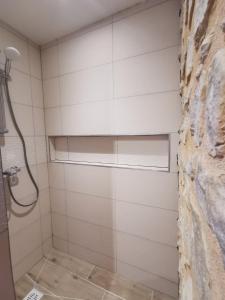 a bathroom with a shower with white tiled walls at Villas Chapu in Fontainebleau