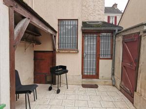 a patio with a grill and a door and a building at Villas Chapu in Fontainebleau
