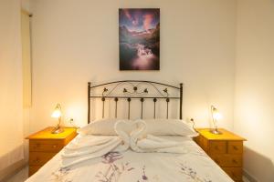 1 dormitorio con 1 cama con 2 mesitas de noche y 2 lámparas en Apartamentos Leomar I, en Los Llanos de Aridane