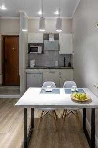 una cucina con tavolo e piatto di frutta di Apartment Comfort plus IQ a Gatchina