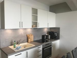 een keuken met witte kasten en een wastafel bij Speicher Residenz Barth E2 App 3 in Barth
