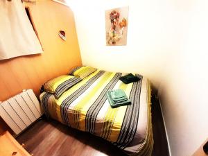 a small bed in a corner of a room at Gîte LaO in Gérardmer