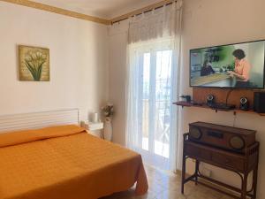 レアルモンテにあるApartment with Sea View, Lido Rosselloのベッドと薄型テレビのある寝室