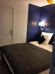 a bedroom with a large bed with a blue headboard at Appartement Alpin à 200m des pistes pour 6 in Val Louron