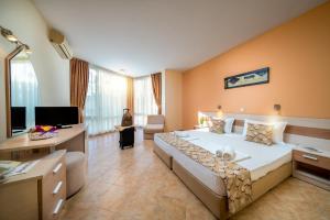 um quarto grande com uma cama grande e uma secretária em Aurelia Beach Complex em Ravda