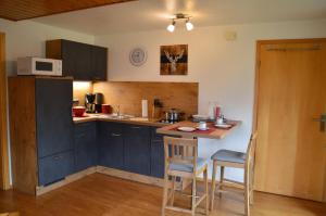 een keuken met blauwe kasten en een tafel en stoelen bij Landhaus Kaspar in Bad Hindelang